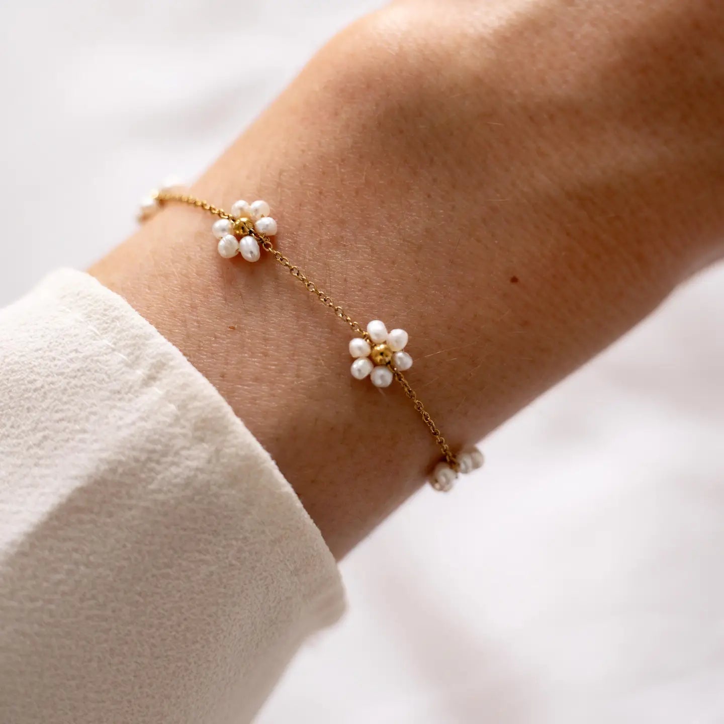 Armband mit weißen Perlenblumen