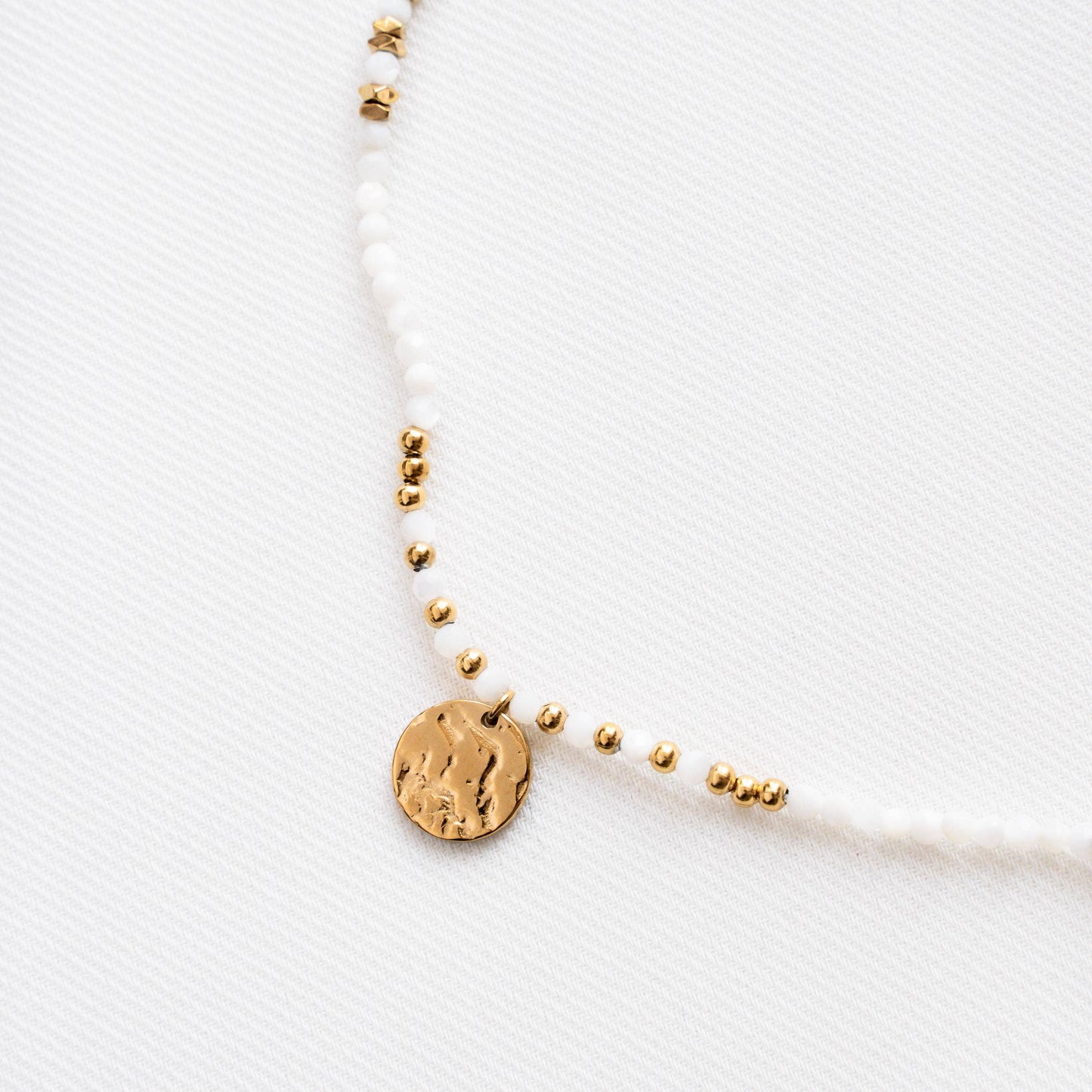 Kette mit weißen Perlen und goldenem Münzanhänger