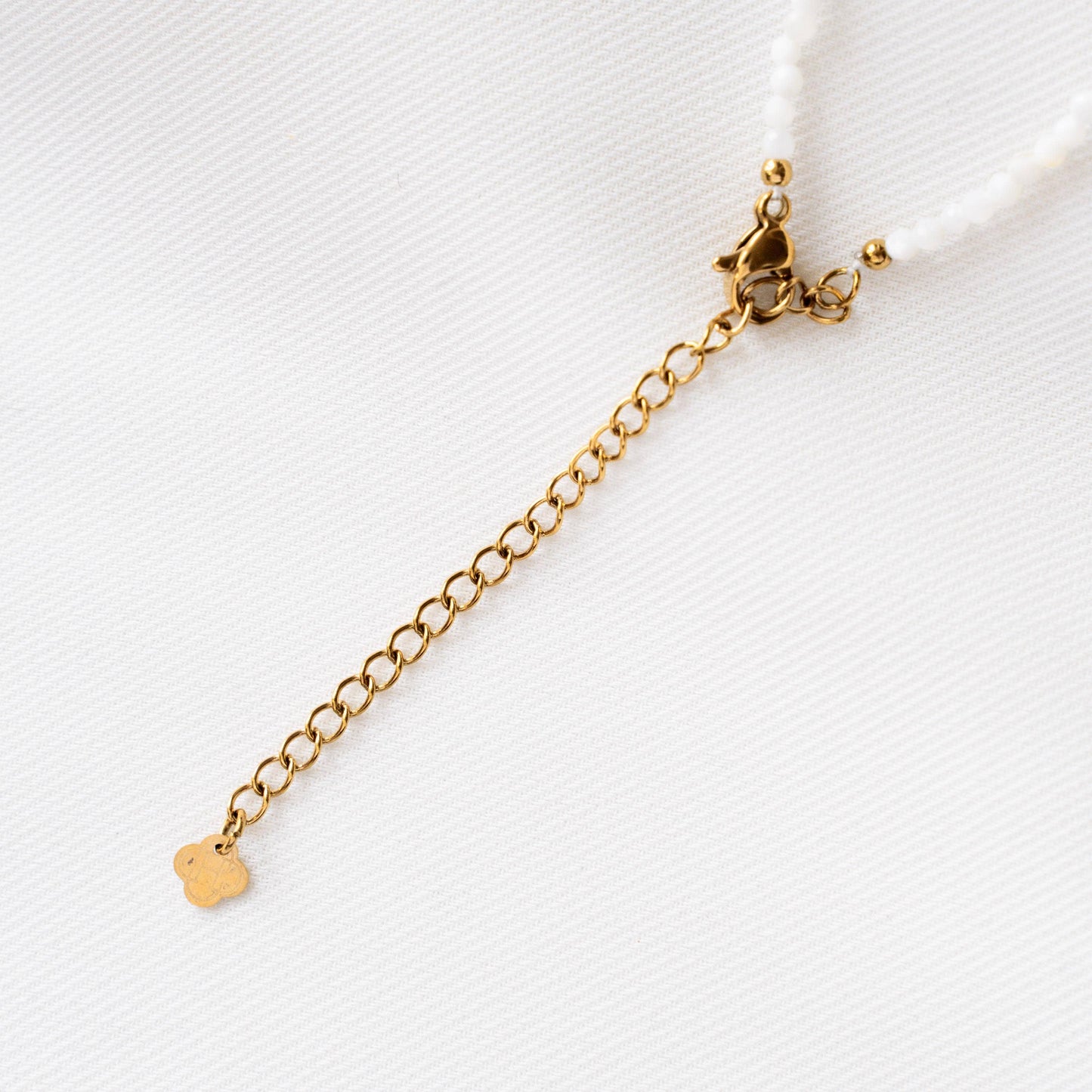 Kette mit weißen Perlen und goldenem Münzanhänger
