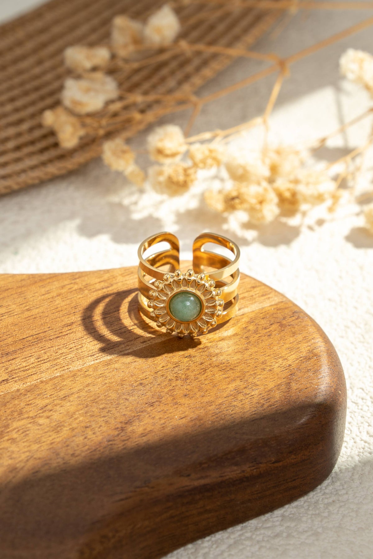 Goldener Damenring mit grünem Stein und Sonnenmotiv