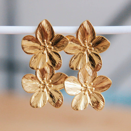 Goldfarbene Edelstahl Ohrringe mit zwei großen Kirschblüten für einen eleganten Look.