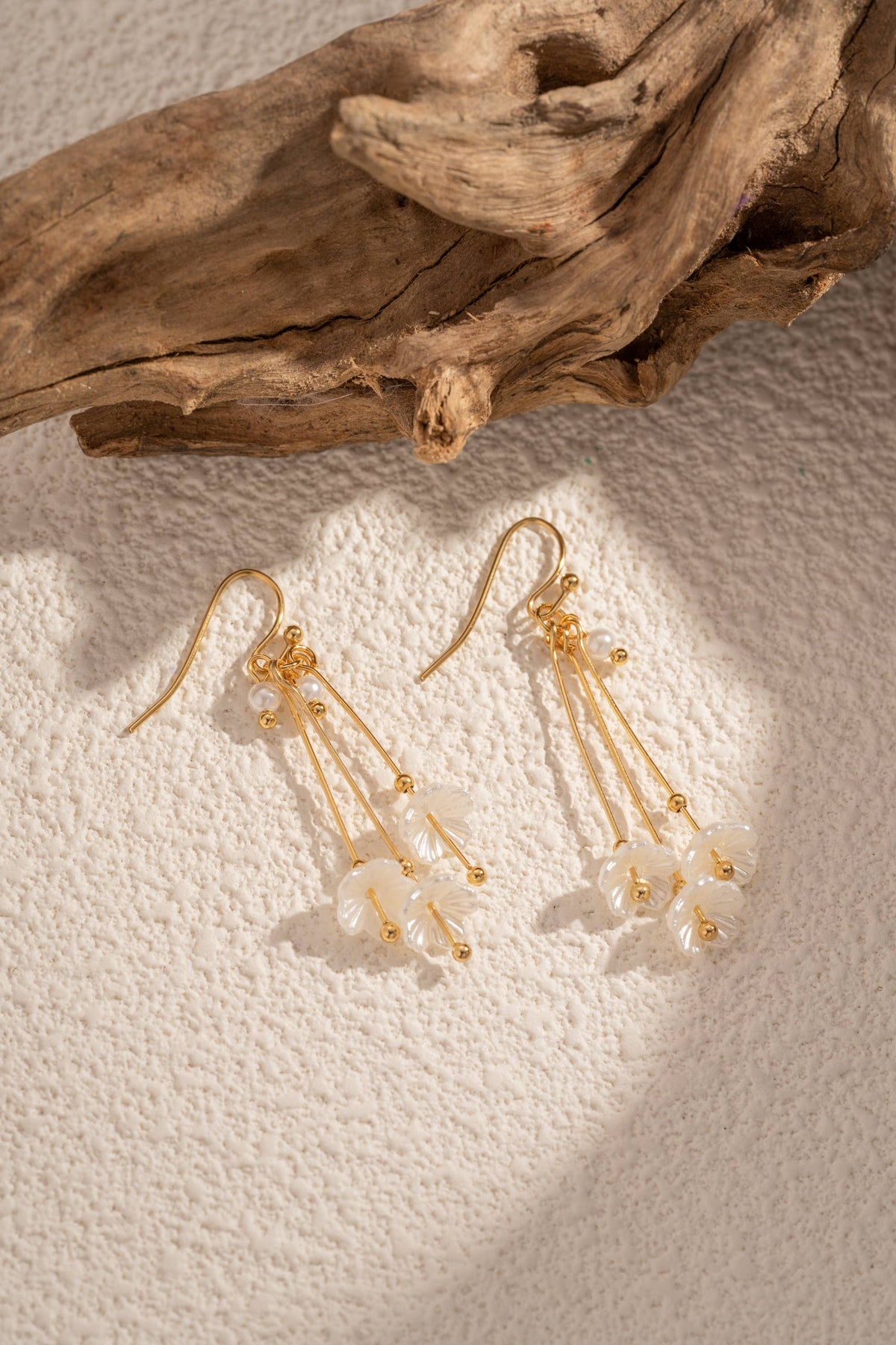 Goldene Ohrringe mit schimmernden Blütenblättern