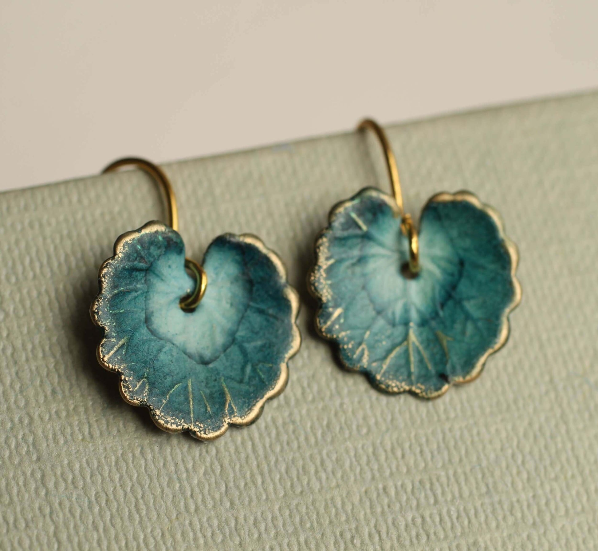 Elegante marineblaue Seerosen Blatt Ohrringe aus handbemaltem Messing mit goldenem Anhänger.