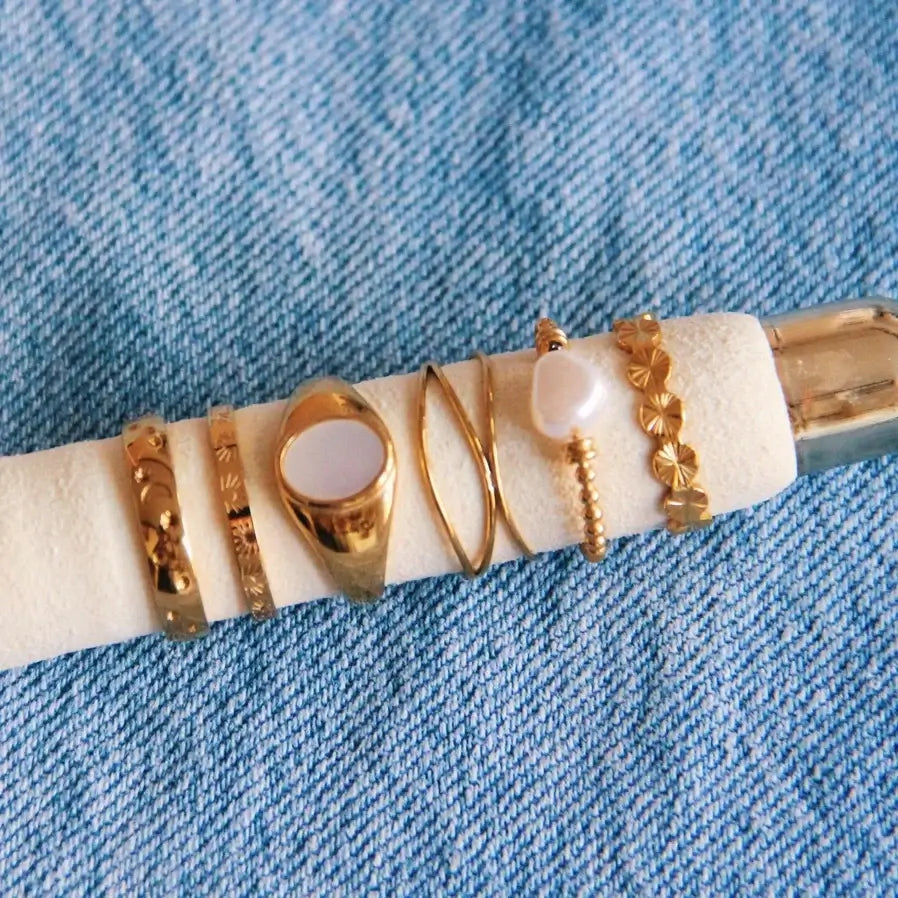 Elegante goldfarbene Edelstahlringe auf einem weißen Kissen, ideal für minimalistische Schmuckliebhaber.