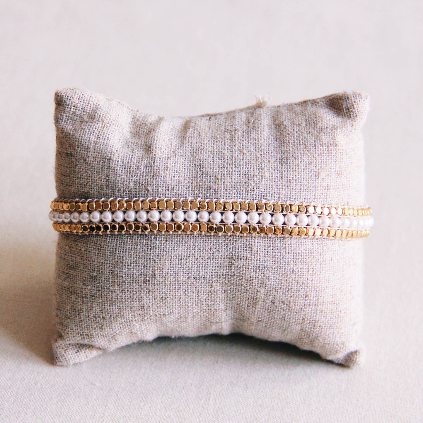 gewebtes boho perlenarmband mit edelstahl steinen und weißen perlen.