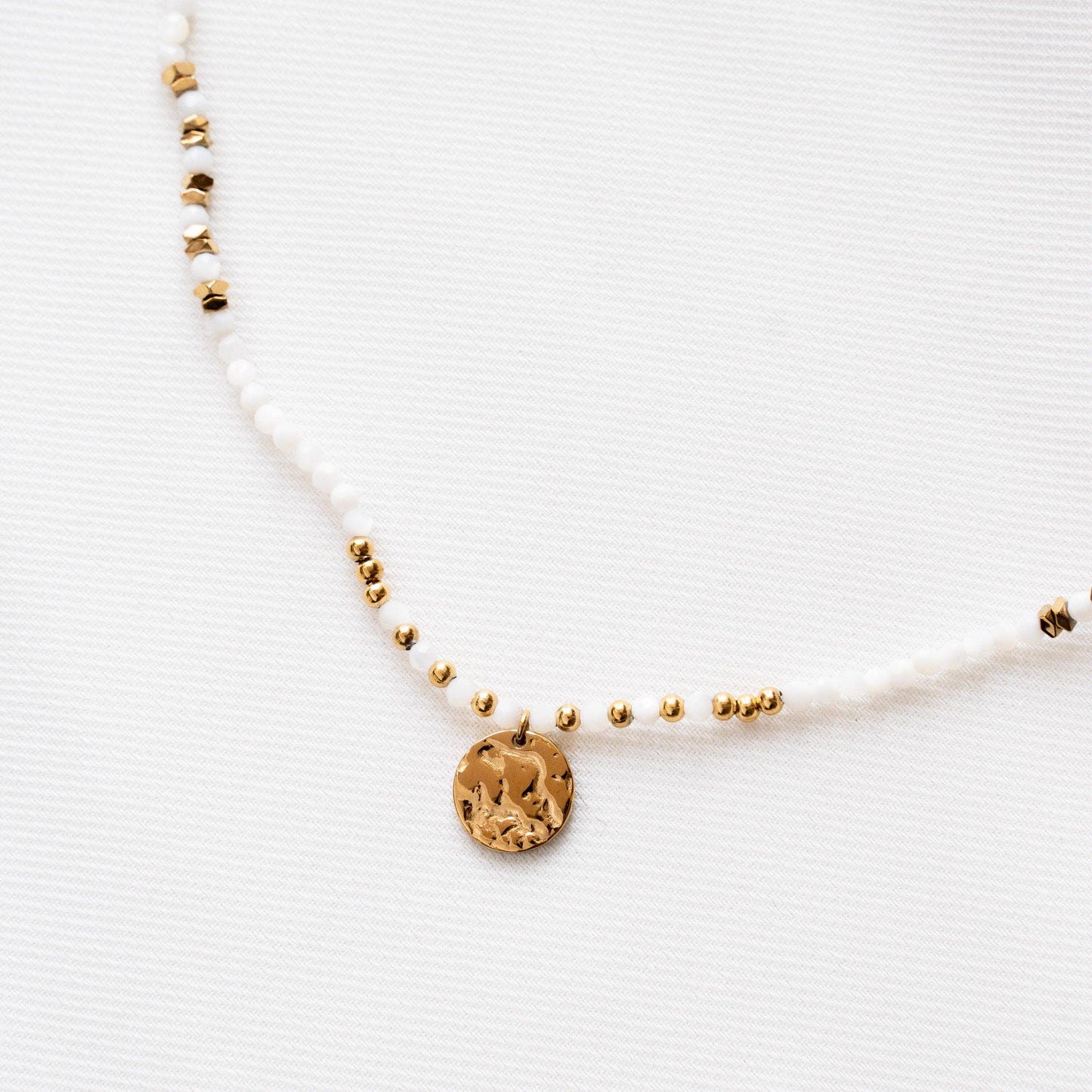 Kette mit weißen Perlen und goldenem Münzanhänger