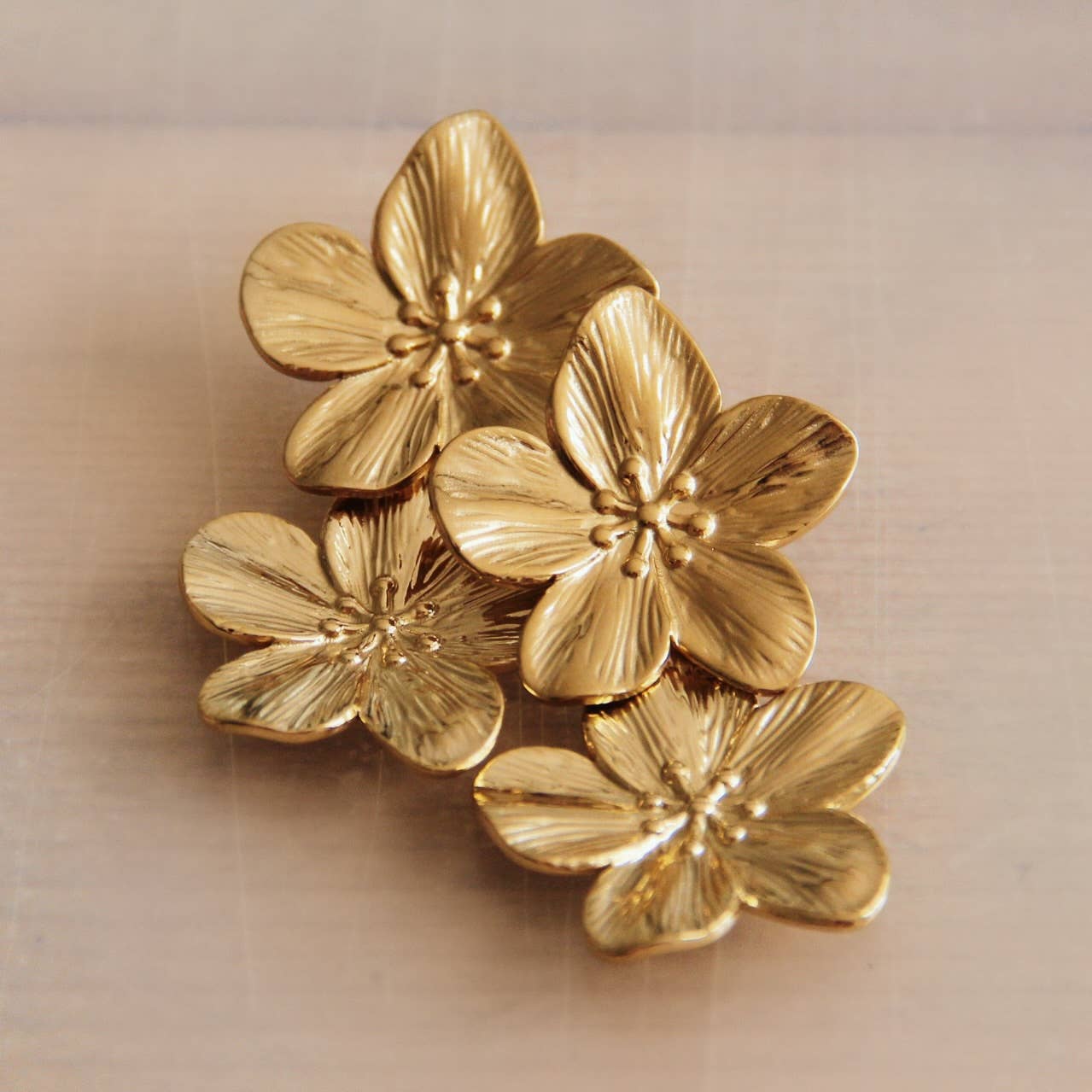 Goldfarbene Kirschblüten Ohrringe aus Edelstahl mit zwei großen Blüten für eleganten Stil.