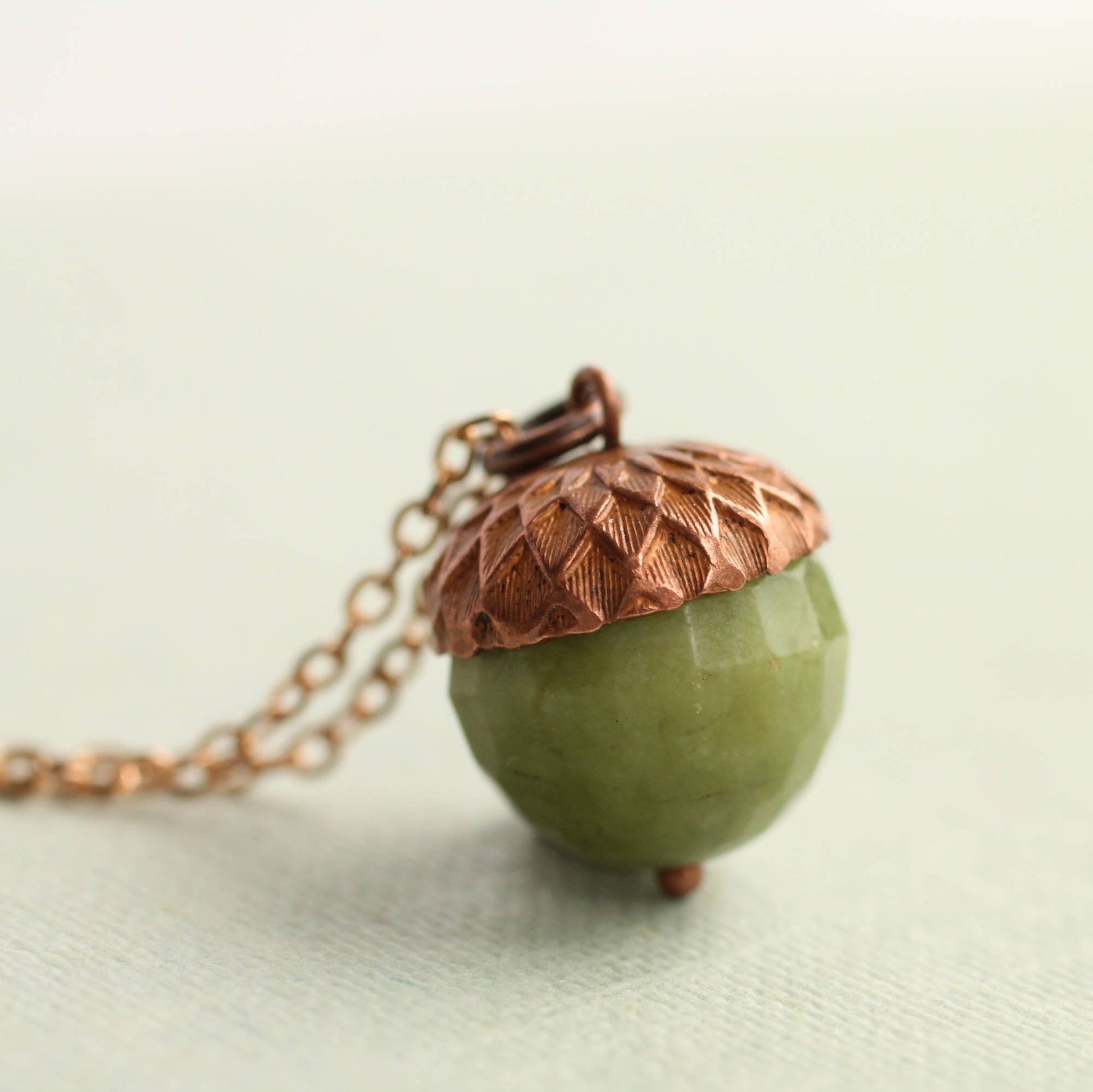 einzigartige Kette mit einem grünen Stein in form einer eichel. Natur schmuck für naturliebhaber
